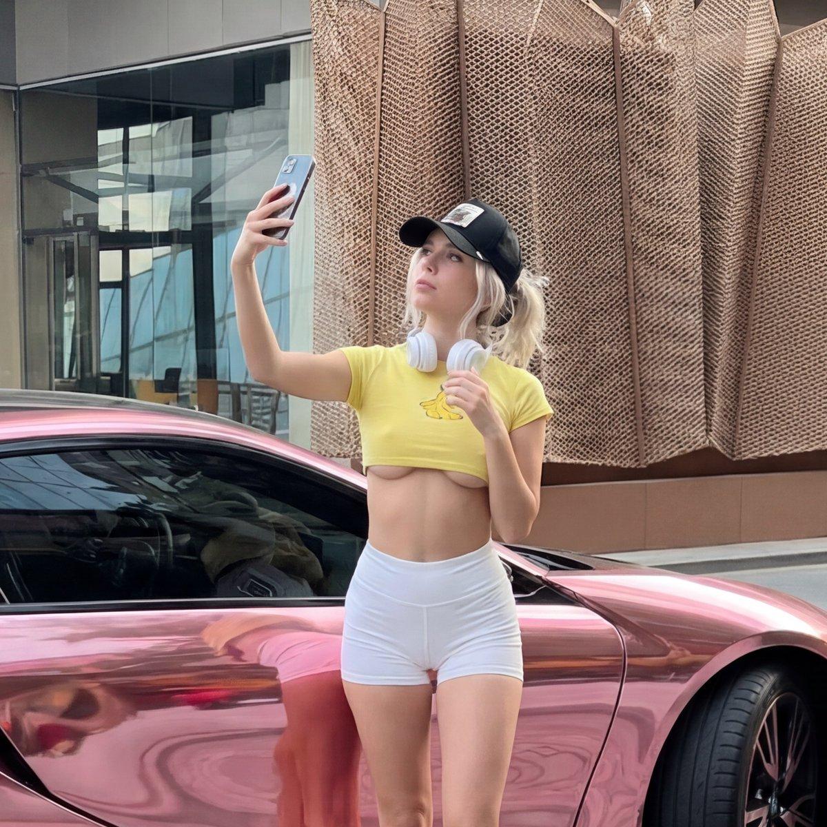Nano Banana prompt example showing woman taking selfie beside chrome pink BMW